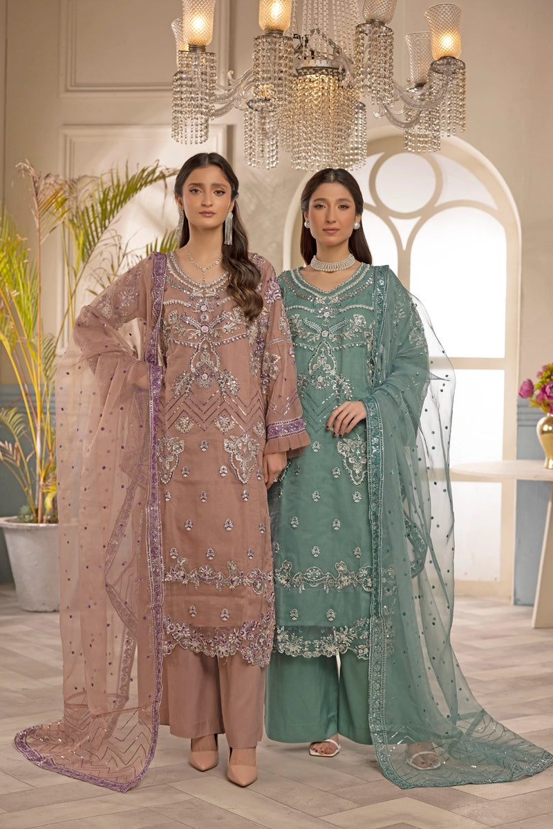 Two women in traditional embroidered outfits standing in a decorated room with a chandelier.
