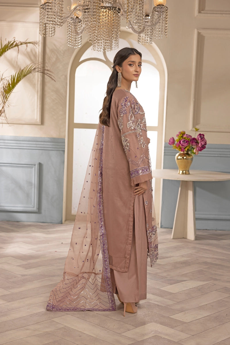Woman in a traditional outfit standing in a stylish room with decor elements.