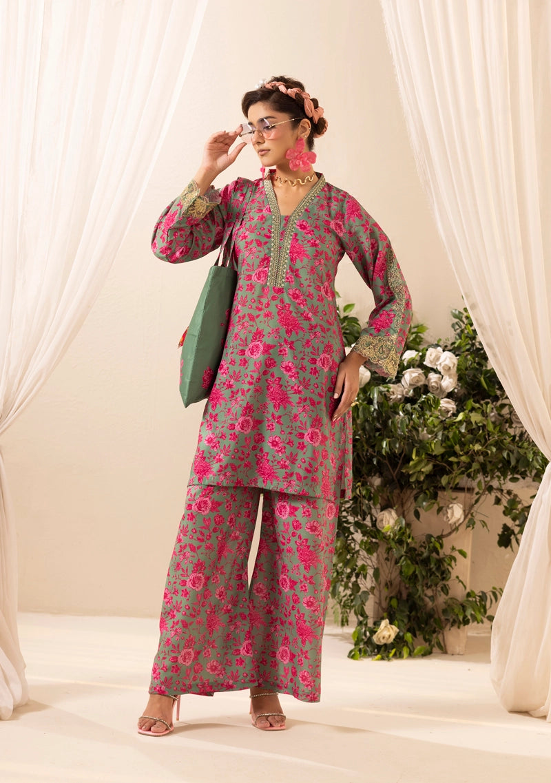 Woman wearing a floral outfit with a green bag in a decorated indoor setting