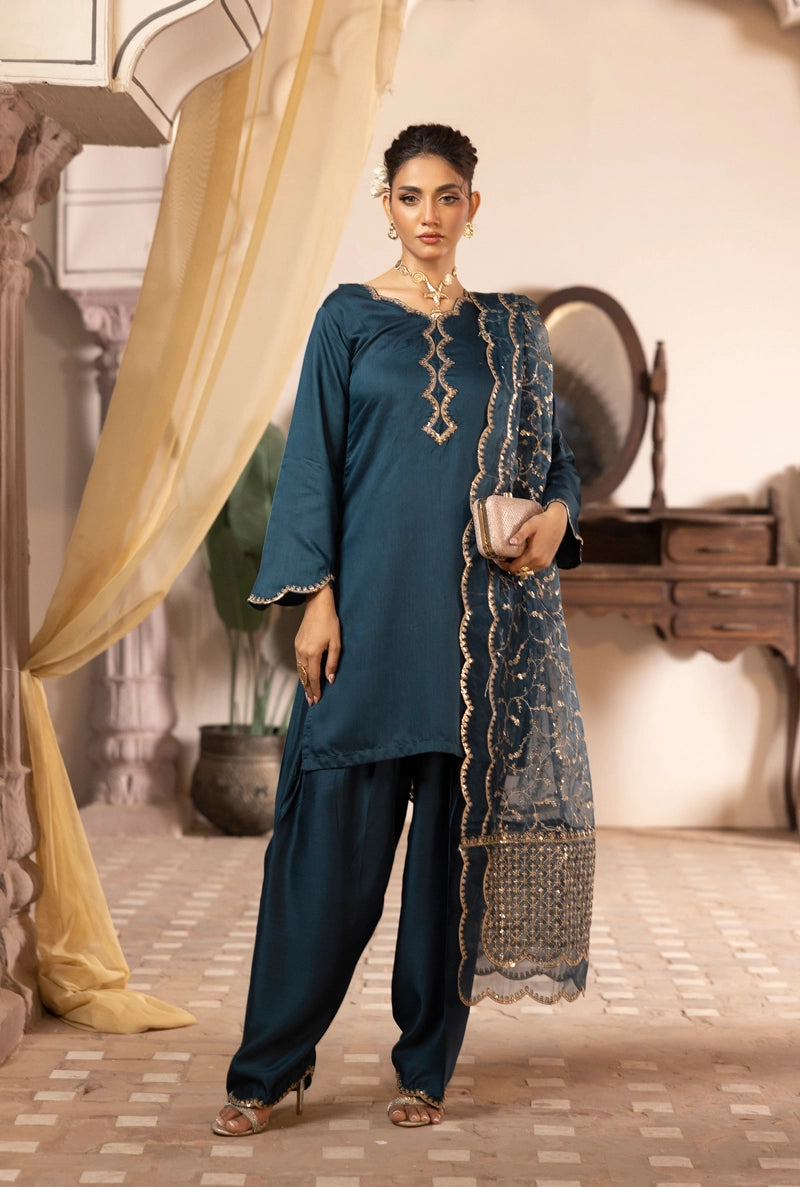 Woman in teal traditional outfit with lace details in a decorative setting