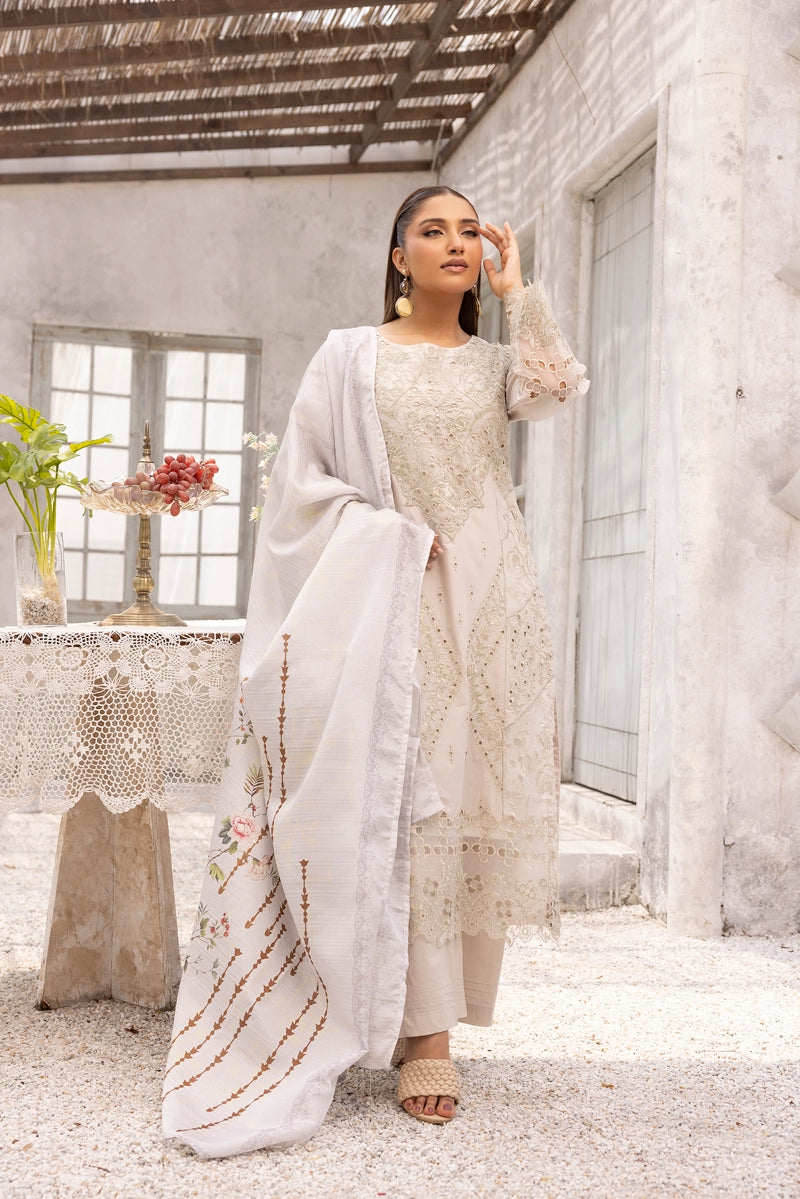 Woman in a light-colored traditional outfit standing in a bright, minimalistic room.