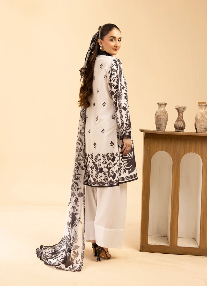 Woman wearing a white outfit with black floral patterns, standing against a beige background.