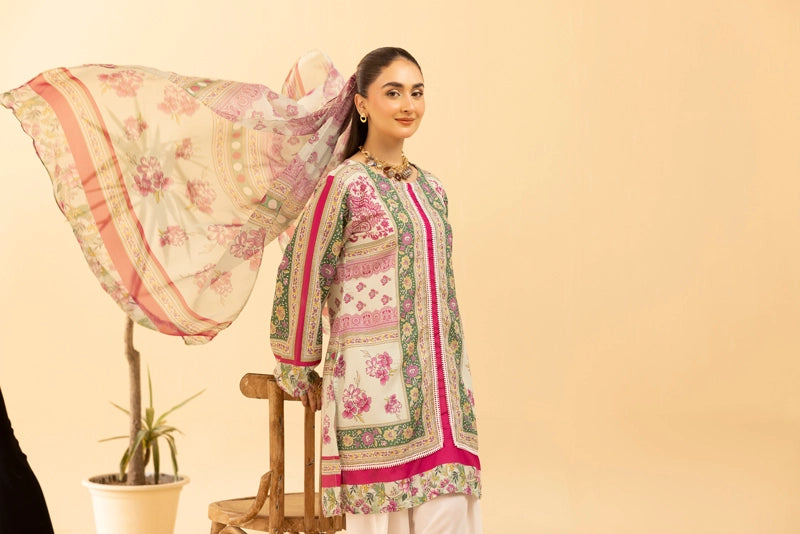 Woman wearing a floral embroidered outfit with a shawl against a beige background