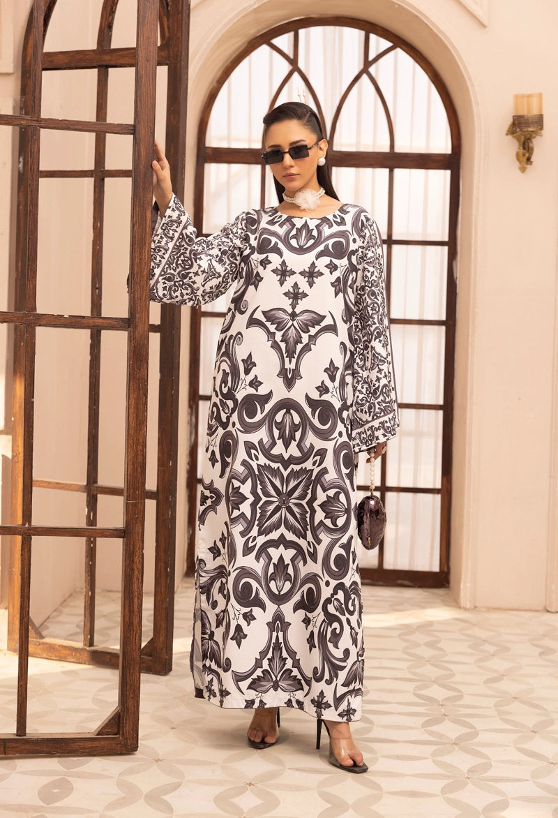 Woman wearing a black and white patterned dress standing in a room with decorative elements.