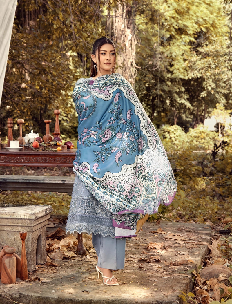 Woman wearing a blue and white patterned shawl in a forest setting
