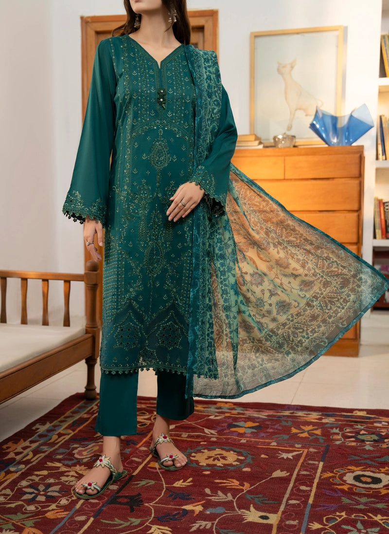 Woman wearing a teal embroidered outfit with a matching dupatta in a room.