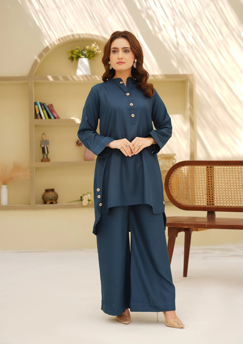 Woman wearing a blue outfit in a well-lit room with a neutral background