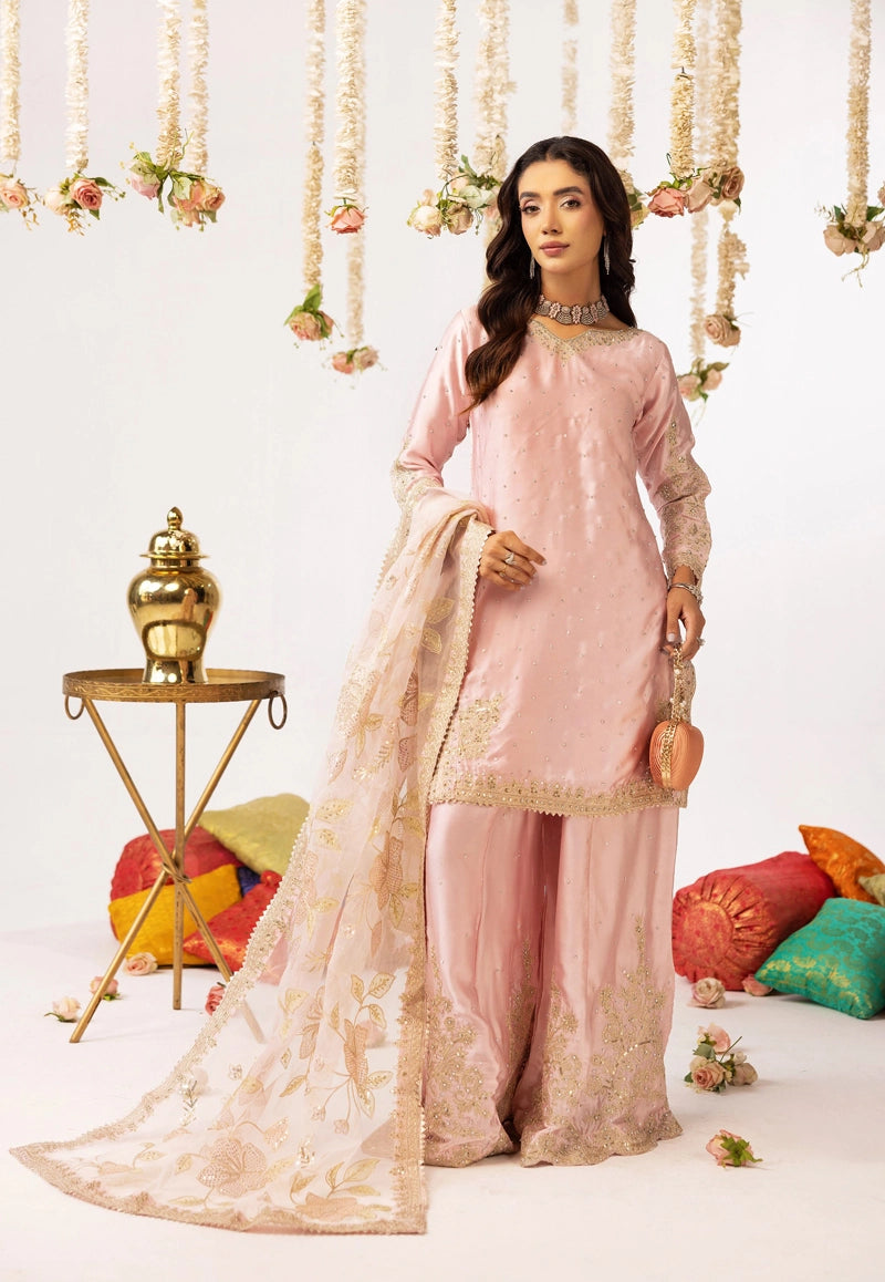 Woman in a pink traditional outfit with gold embroidery in a decorated setting
