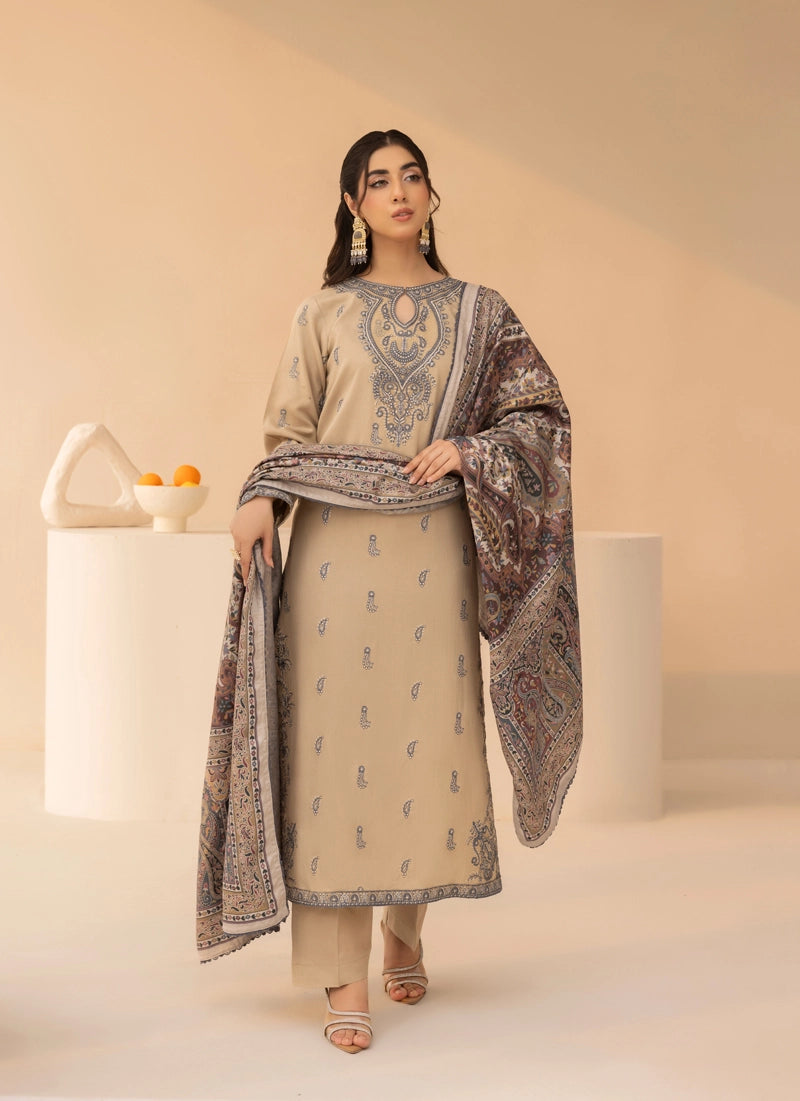 Woman wearing a beige and patterned outfit with a scarf against a neutral background