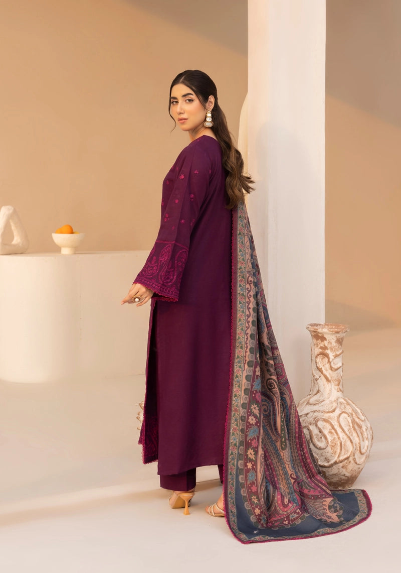Woman in a maroon outfit with a patterned scarf standing indoors.