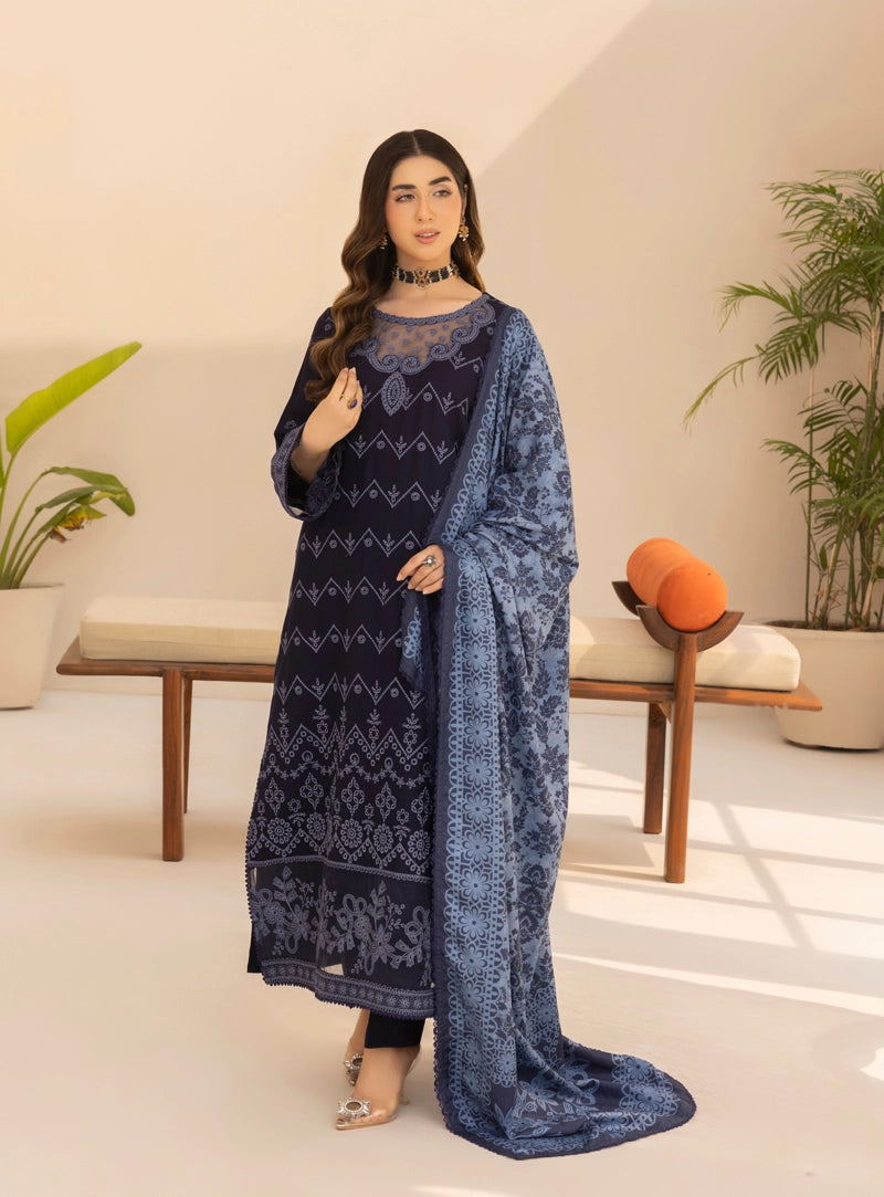 Woman wearing a blue embroidered dress in a modern indoor setting